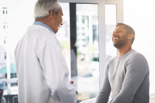 Youre in great shape. a senior doctor giving his male patient a thorough checkup during his consultation