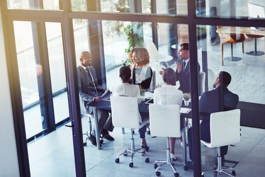 Their meeting was a roaring success. a team of professionals having a meeting in the boardroom at work