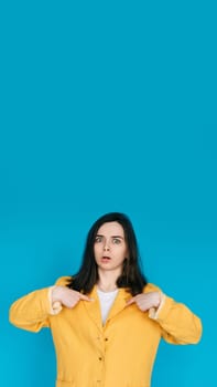 Young Frustrated University Student Pointing Fingers at Herself, Feeling Unhappy and Angry - Exam Stress, Forgetfulness, Isolated on Blue Background.