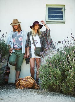 Keeping their style hipster. a trendy young couple standing together against the wall of a building outside