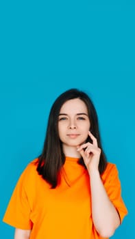 Thoughtful Woman Touching Chin, Contemplating, Copy Space, Isolated on Blue Background. Portrait of a Beautiful Woman Touching Her Chin, Contemplating.