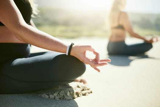 Life is all about being in the now. an unrecognizable woman practising yoga on the beach