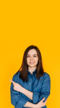 Engaging Businesswoman: Confident Young Female in Formal Office Attire with Bright Smile, Pointing at Blank Space - Isolated on Vibrant Yellow Background.