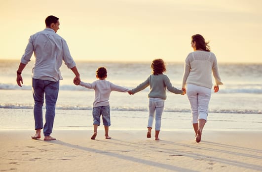 Walking, beach and back of family holding hands on holiday, summer vacation and weekend at sunset. Nature, travel and mother, father and children by ocean for bonding, adventure and quality time.