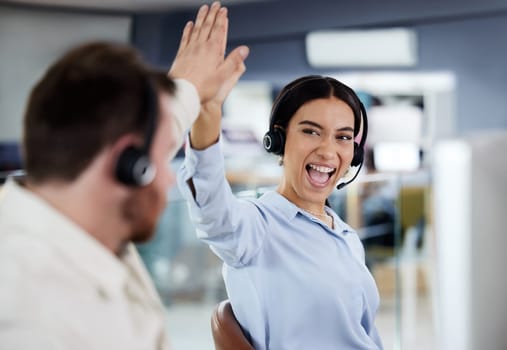 Support, colleagues with headset and at their desk of a modern workstation office. Collaboration or teamwork, happiness or call center agents and coworkers celebrating for achievement together.
