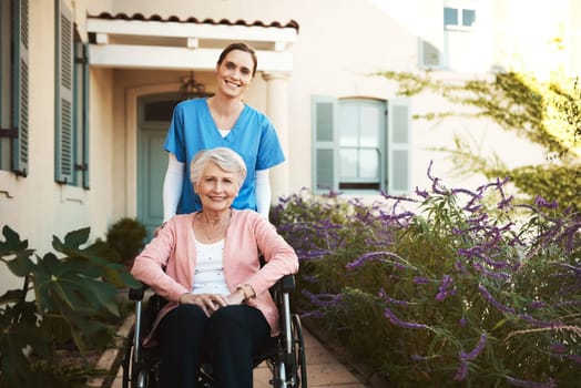 Senior woman, wheelchair and portrait of nurse in healthcare support or garden walk at nursing home. Happy elderly female and caregiver helping patient or person with a disability in retirement.