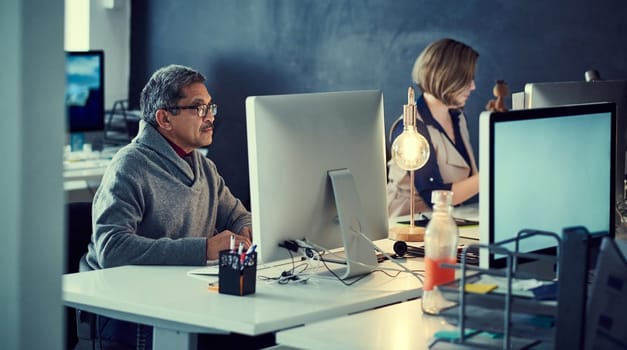 Committed to accomplishing their deadlines. two businesspeople working late in an office