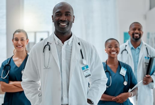 Happy, doctor and portrait of black man with team for medical help, insurance and trust in clinic. Healthcare, hospital and professional male and women health worker for service, consulting and care.