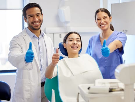 Dentist team, patient and thumbs up portrait for.consultation, clean or teeth whitening. Woman, asian man or healthcare staff and client together for dental care, oral health exam and mouth cleaning.