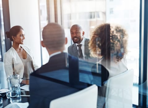 Reviewing the performance of their company. a team of professionals having a meeting in the boardroom at work