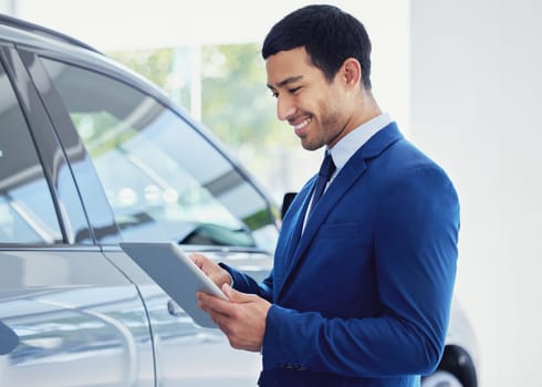 Tablet, car and salesman smile at showroom, workshop or salon workplace. Internet, technology and male person at dealership for motor vehicle shopping, web scroll and email app in auto retail store