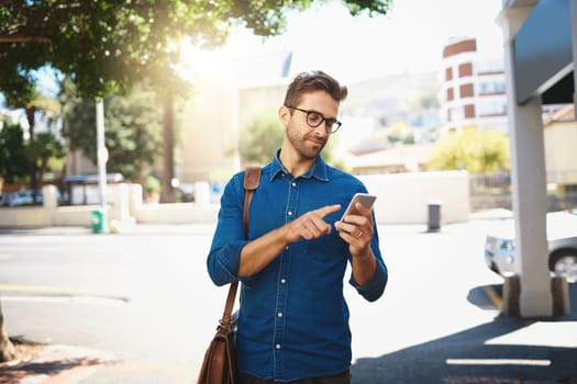 I get my directions online. a handsome man using his cellphone while out in the city