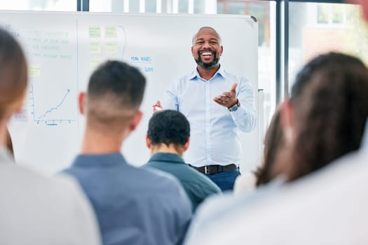 Business, coach and presentation with employees for a seminar with explanation and smile. Speaker, professional and corporate team for training or learning at a meeting with audience for discussion