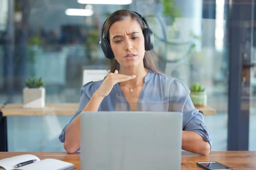 Business woman, laptop and headphones for a webinar, video conference or video call on zoom in a office. Entrepreneur serious while talking at computer screen for training, learning or online meeting.