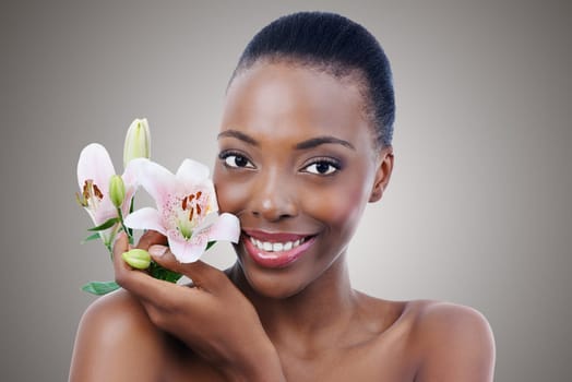 Skincare and beauty. A beautiful african woman posing with flowers - closeup