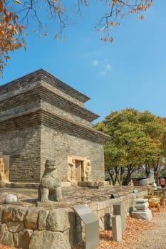 sky,grave,tree,facade,building,cloud,grass,plant,daytime,cemetery,architecture,house,landmark,landscape,monument,temple