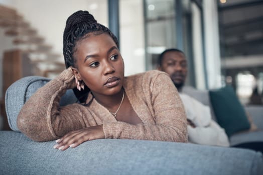 Is this relationship what I really want. a young couple sitting on the sofa and giving each other the silent treatment after an argument