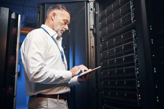 He leaves every client with the best connection. a mature man using a digital tablet while working in a server room