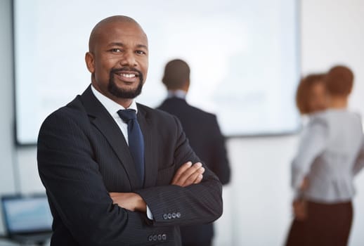 Success looks good on me. Portrait of a mature businessman in the office with his colleagues in the background