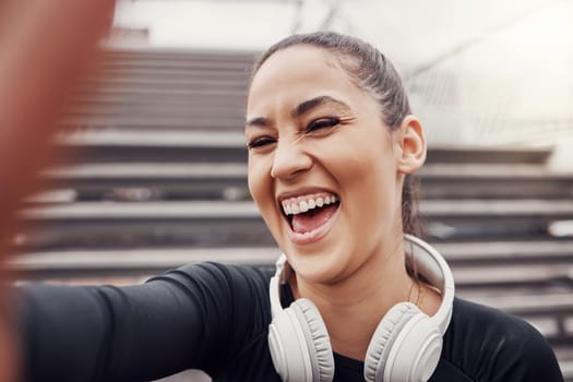 Woman, face and selfie with headphones and exercise in city, happy in Brazil, laughter and fitness outdoor. Runner, cardio and happiness in picture, health and wellness with active lifestyle.