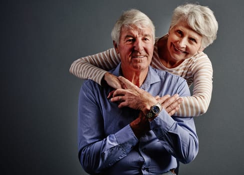 Ive always got his back. Studio portrait of an affectionate senior couple posing against a grey background
