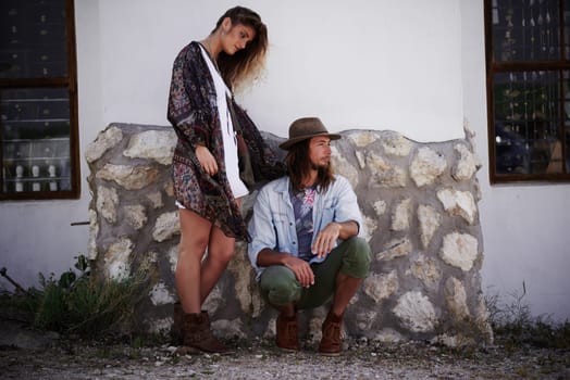 One of the coolest couples around. a trendy young couple standing together against the wall of a building outside