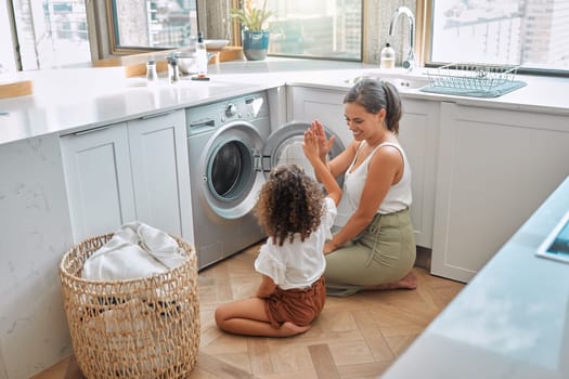 High five, laundry and washing machine with mother and daughter for helping, learning and cleaning. Housekeeping, teamwork and basket with woman and young girl in family home for teaching and clothes.