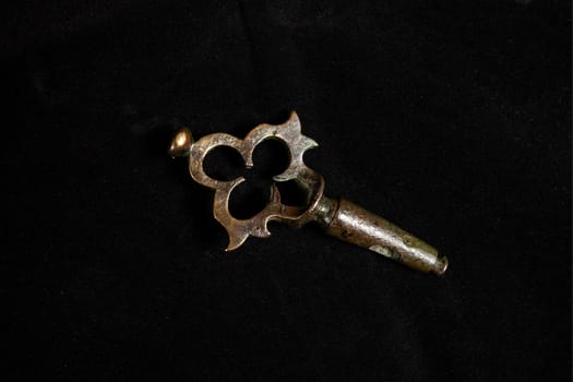 Gold key on a black background. Vintage copper lock key. High quality photo