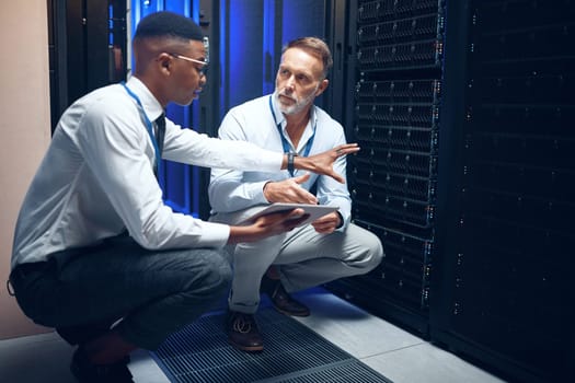 We cant allow any flaws to filter through. two technicians using a digital tablet while working in a server room