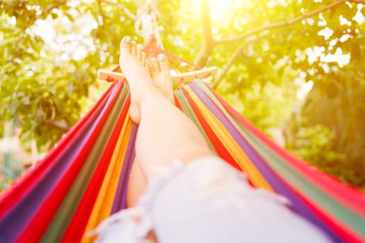 Woman relaxing in a hammock in a summer garden.