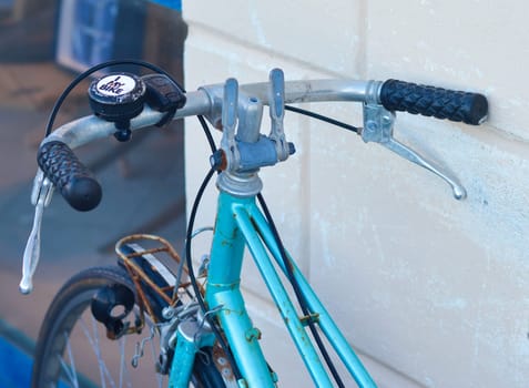 Old blue rusty bicycle on a street in France.