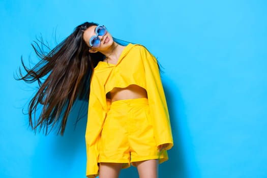 woman joyful emotion funny person joy sunglasses expression trendy beautiful young fashion attractive girl happiness lovely lifestyle blue: monochrome yellow gesture outfit