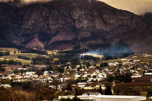 Urban development, suburb or cityscape by mountain, buildings and housing in Cape Town. Outdoor, landscape and mountains with houses, night and hill for real estate, property or holiday by skyline.