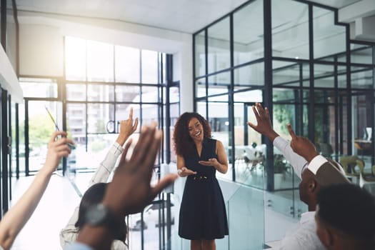 Its time for our QA session. Closeup shot of a group of businesspeople raising their hands during a presentation in an office