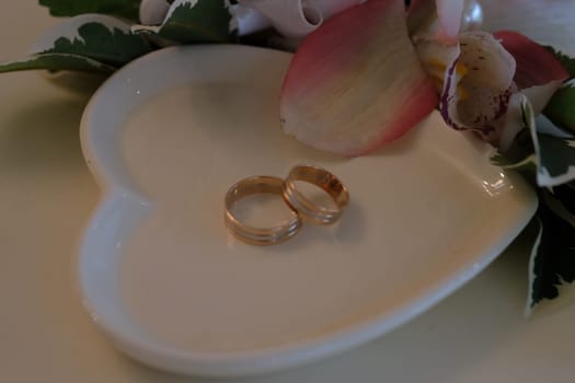 Wedding rings on a white saucer. High quality photo