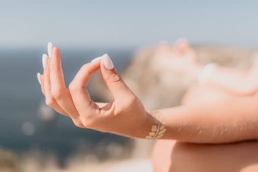 Woman meditating in yoga pose silhouette at the ocean, beach and rock mountains. Motivation and inspirational fit and exercising. Healthy lifestyle outdoors in nature, fitness concept.