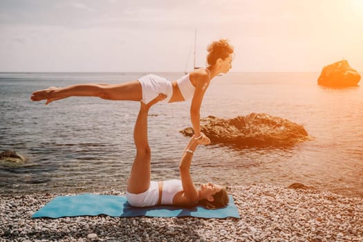 Woman sea yoga. Back view of free calm happy satisfied woman with long hair standing on top rock with yoga position against of sky by the sea. Healthy lifestyle outdoors in nature, fitness concept.