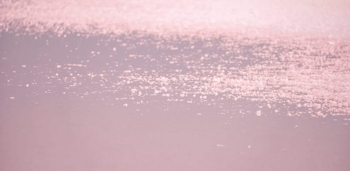 Salt mining. Salty pink lake with crystals of salt. Extremely salty pink lake, colored by microalgae with crystalline salt depositions