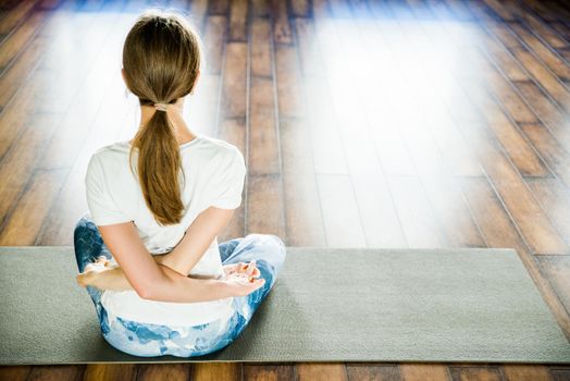 Health concept. Young attractive woman does yoga exercise in the gym against white wall