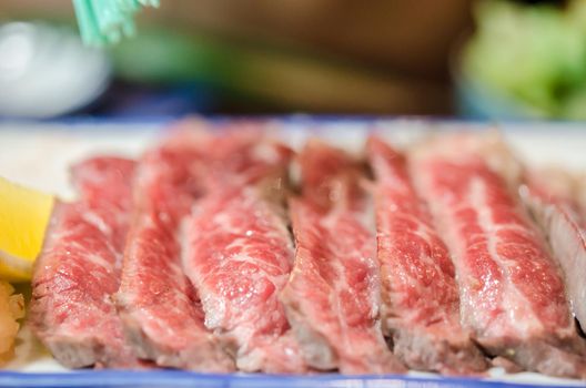 Sliced grilled Strip Loin rare degree of ripeness beef steak served with salt and lime.