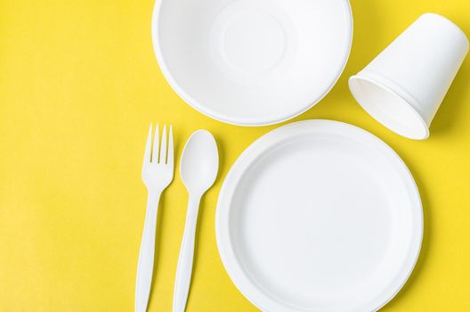 Eco friendly biodegradable paper disposable for packaging food and paper glass on yellow background.