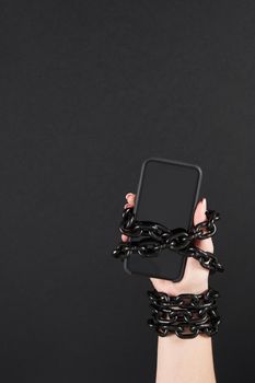 Close-Up Of Person Holding Mobile Phone And Chain