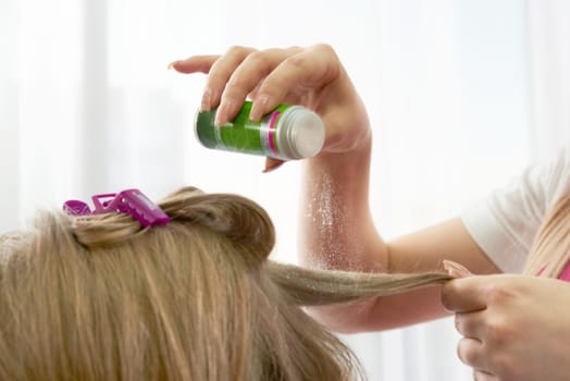Hairdresser puts powder for volume on hair