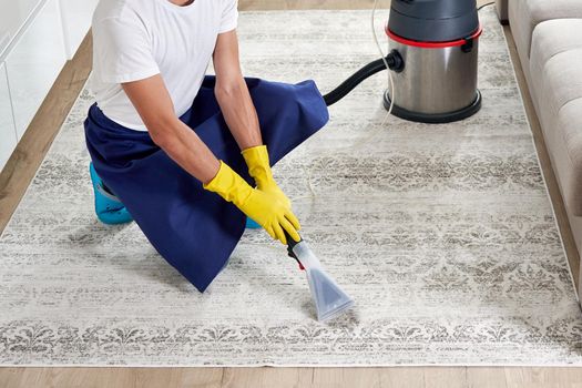 Close-up Of A Person Cleaning Carpet With Vacuum Cleaner