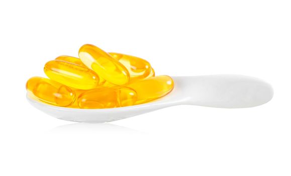 Fish oil supplement capsule in white spoon isolated on white background. Save clipping path.