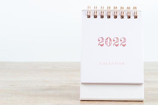 Desk calendar 2022 on wooden background.