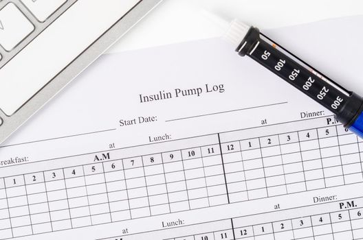 Insulin pump log record form and syringe wiht insulin for patient.