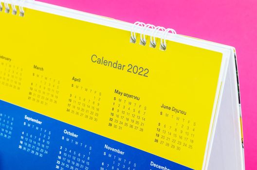 Dates on calendar page 2022 on pink background.