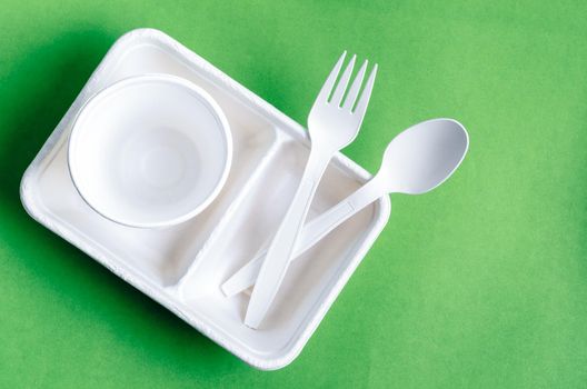 Eco friendly biodegradable paper disposable for packaging food and paper glass on green background.