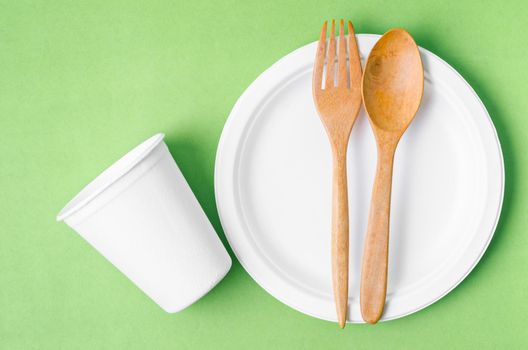Eco friendly biodegradable paper disposable for packaging food and paper glass on green background.